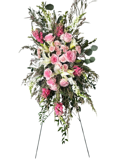 Floral arrangement with pink and white flowers on a stand against a white background