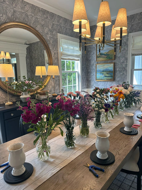 Dining room with a table set with flowers, vases, and decorative items.